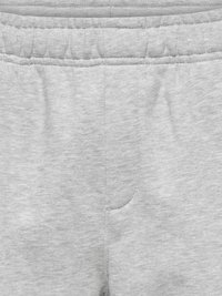 Taille de pantalon de jogging gris clair avec bande élastique et détails de couture visibles sur un tissu doux.