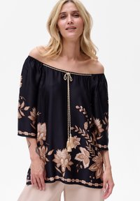 Czarna bluzka na ramiączkach z złotym haftem kwiatowym, krótkie rękawy i pleciony sznurek przy dekolcie z frędzlami.