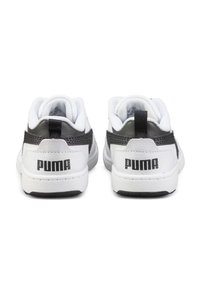 Sneaker bianchi con accenti e logo neri, dotate di un tallone in pelle testurizzata e collare imbottito. Suole in gomma con motivo antiscivolo.