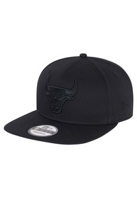 Gorra snapback negra con un logotipo de toro bordado en la parte frontal, visera plana, tejido texturizado y una pegatina de New Era en el ala.