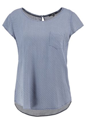 Blouse bleue à manches courtes avec motif géométrique blanc, encolure ronde, petite poche poitrine et fermeture à boucle bouton au col arrière.