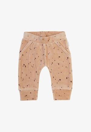 Pantalons doux beiges avec une texture veloutée et des taches brunes éparpillées. Ils possèdent une taille élastique et deux poches latérales.
