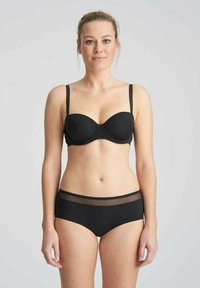 Set di lingerie nero composto da un reggiseno balconcino con coppe modellate e spalline sottili, abbinato a slip a vita alta con bordo in rete trasparente.