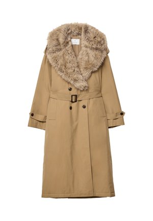 Pitkä beige trench-takki, jossa on leveä tekoturkiskaulus, kaksirivinen napitus, vyöllinen vyötärö ja nappikiinnitteiset hihansuut.