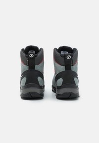 Grå og svarte turstøvler har høyt design, suede materiale, gummisåler og røde detaljer langs sømmene.
