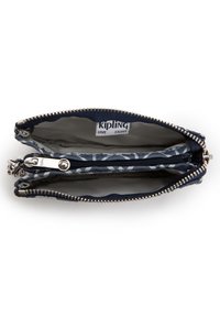 Námořnická látková peněženka se zipovým uzávěrem, která má světlé vnitřní prostory a malou zipovou kapsičku uvnitř. Viditelné logo Kipling.