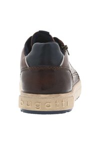 Baskets en cuir marron avec accents bleu marine, semelle beige texturée et logo embossé. Présente une forme de bout arrondi et un talon rembourré.