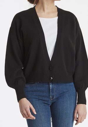 Cárdigan negro corto con escote en V, cierre de botones y mangas oversized. Fabricado en una tela suave, con puños y dobladillo acanalados.