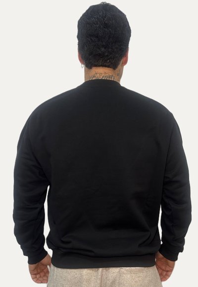 Felpa nera con scollo rotondo, maniche lunghe e vestibilità morbida. Il tessuto appare liscio senza motivi o dettagli visibili.