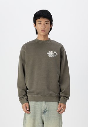 Sudadera verde oliva con cuello redondo, mangas largas y puños acanalados. Presenta el texto del logo "REPLAY" en blanco en la parte izquierda del pecho.