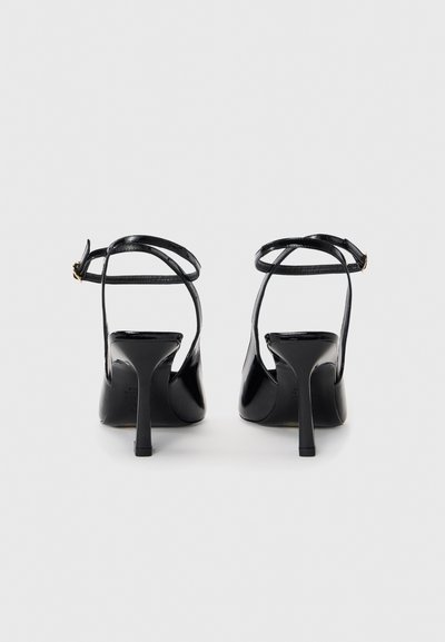 Black patent heeled sandals with thin ankle straps, a pointed toe, and a stiletto heel. Smooth texture with minimal detailing.