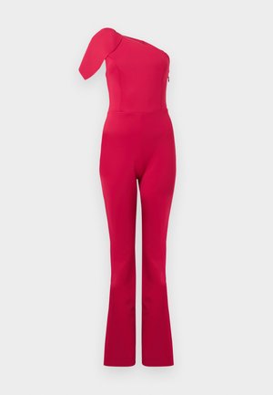 Φωτεινό ροζ ολόσωμο φόρεμα με έναν ώμο, εφαρμοστό μπούστο και φαρδιά παντελόνια σε απλό φωτεινό φόντο.