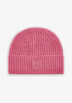 Bonnet en tricot rose avec une texture côtelée, un revers replié portant un patch carré, et un design de fleur en relief sur le patch.