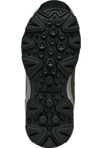Semelle de chaussure en caoutchouc noir avec surface texturée, motifs circulaires et angulaires, dotée de trous de ventilation et d'un logo "GEOX".