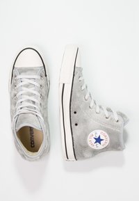 Szare sneakersy wysokie Converse All Star z futra syntetycznego, z białymi gumowymi podeszwami i sznurówkami, przedstawione z widoków z góry i z boku.