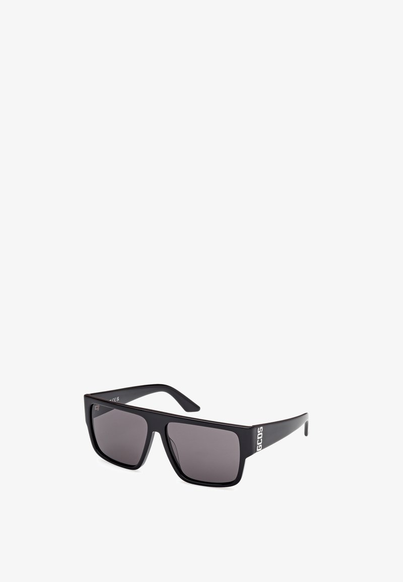 Czarne prostokątne okulary przeciwsłoneczne z szarymi soczewkami, o matowym wykończeniu i strukturalnym wzorze na zausznikach. Logo z jednej strony.
