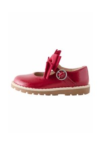 Scarpa Mary Jane in vernice rossa con punta arrotondata, dettagli di fiocco oversize, cinturino per la caviglia con accessori in argento e suola spessa di colore naturale.