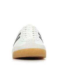 Scarpe da ginnastica bianche con punta in suede e strisce nere sui lati. Presentano una suola in gomma testurizzata e un design con allacciatura tradizionale.