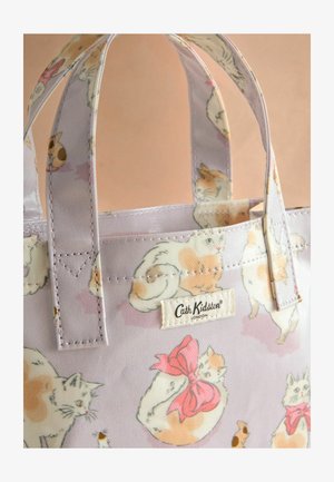 Mažas levandų spalvos pirkinių krepšys su katės atspaudais įvairiomis pozomis, rožiniais kaspinų akcentais ir Cath Kidston logotipu šone.
