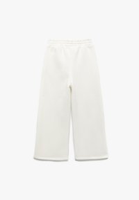 Pantalones de felpa blanca de pierna ancha con cinturilla elástica, extendidos sobre un fondo blanco.