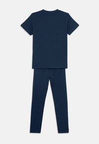 Navy blue puuvillane T-särgi ja legginsite komplekt. T-särk on ümmarguse kaeluse ja lühikeste varrukatega; legginsid on keha kohandavad sileda tekstuuriga.