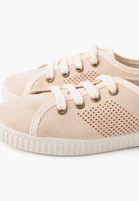 Sneaker beige in suede con superficie texturizzata, punta rotonda, design con lacci e dettagli perforati sui lati; suola in gomma bianca.