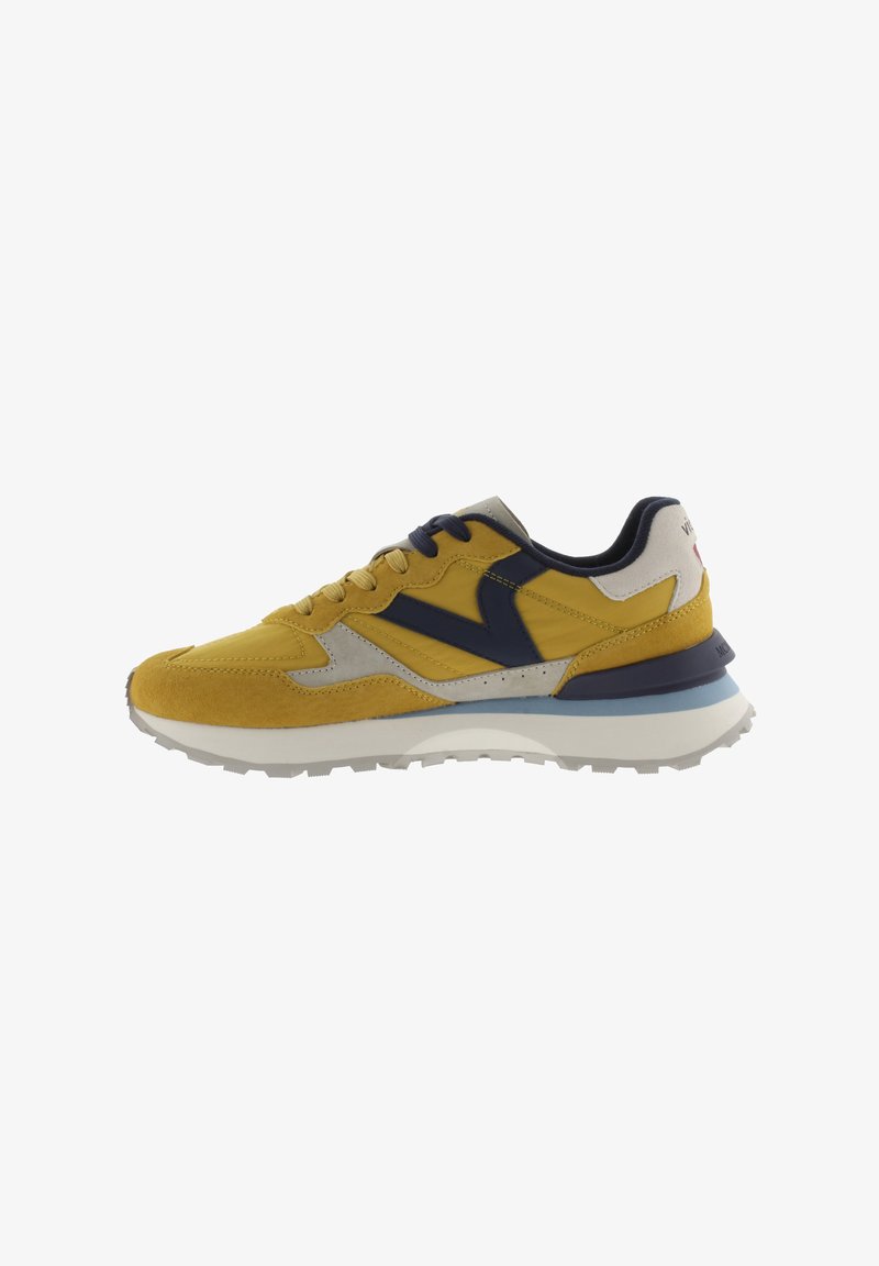 Sneaker giallo e grigio con una combinazione di materiali in suede e rete, caratterizzato da accenti blu navy, suola texturizzata e design con lacci.