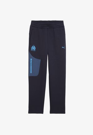 Marineblå sweats med en blå accentlomme, elastisk talje, med Marseille-logoen og Puma-logoen i lyseblå. Blød stoftekstur.