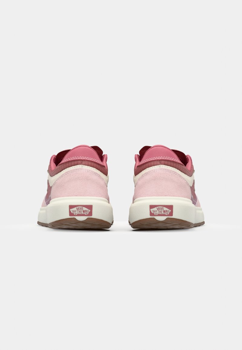 Sneakers in suede rosa con accenti bianchi, dotati di suola imbottita, retro testurizzato e logo Vans sul tallone. Superficie liscia e forma arrotondata.