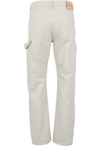 Pantalon beige droit avec deux poches arrière, une poche utilitaire latérale, des passants de ceinture et une étiquette de marque beige sur la taille.
