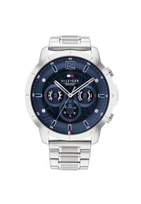 Montre en métal argenté avec un cadran bleu marine, trois sous-cadrans, index horaires blancs et le nom de la marque "HILFIGER" au centre. Détail résistant à l'eau inclus.