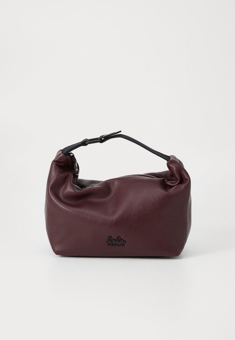 Bolsa de couro burgundy com uma textura suave e enrugada, uma alça ajustável preta e fecho de zip. Apresenta um logótipo discreto na base.