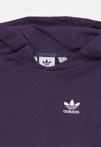 Temno vijolična Adidas kapuca z belim trefoil logotipom na prsih in oznako velikosti vidno v ovratniku.