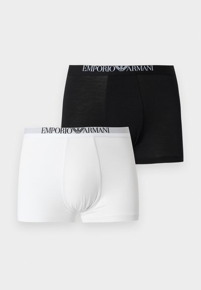 Δύο boxer briefs Emporio Armani, ένα μαύρο και ένα λευκό, και τα δύο με ελαστική μέση με λογότυπο, σε ανοιχτό φόντο.