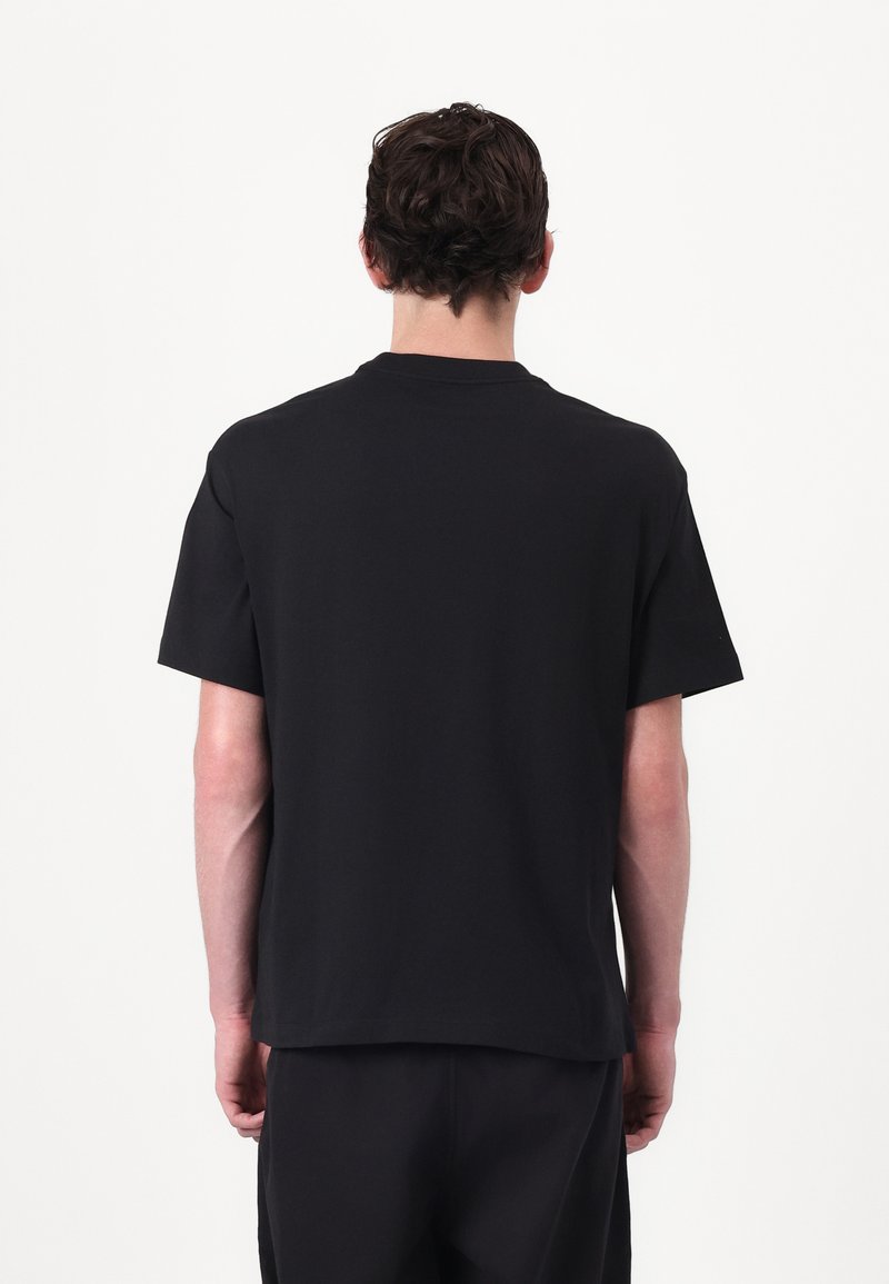 Black cotton t-shirt with a relaxed fit, short sleeves, and a crew neckline, showing a plain design without any visible logos or patterns.