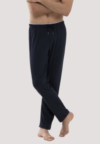 Navyblauwe joggers van lichtgewicht stof, met een elastische tailleband en taps toelopende broekspijpen voor comfort.