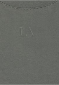 Gray cotton T-shirt with lightweight texture, featuring ribbed fabric and embossed "LA" logo on the front. Smooth neckline.
