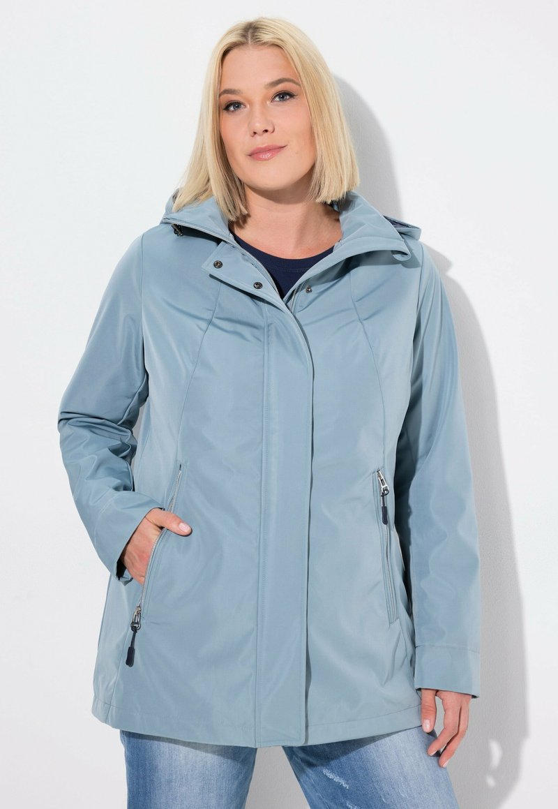 Ljusblå vattentät jacka med huva, utrustad med en framzipper, två sidofickor och en stilren, något figursydd design.