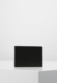 Zwarte leren portefeuille met een zachte textuur, rechthoekige vorm, reliëflogo op de voorkant en een minimalistisch ontwerp.