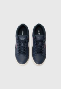 Navy blue sneakers with smooth synthetic upper, white rubber sole, and black laces. Features brand logo and red accents on the side.
