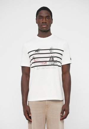 Maglietta bianca in cotone con righe orizzontali nere, stampa grafica con testo e piccolo logo sulla manica sinistra.