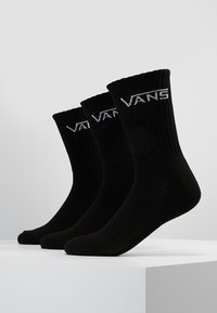 Calcetines negros de canalé con puños elásticos, adornados con el logo blanco "VANS" en la parte frontal, diseñados para la comodidad y durabilidad.