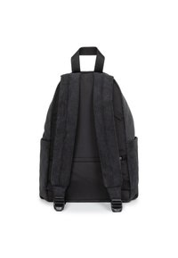 Zaino nero con manici in corduroy, corpo testurizzato, due tasche laterali e una maniglia superiore. Presenta cuciture a contrasto e spallacci regolabili.