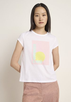 Weißes Baumwoll-T-Shirt mit kurzen Ärmeln, das ein pastelliges Grafikdesign mit einem gelben Kreis und Text in Mint und Pink zeigt. Gerader Schnitt, lässiger Stil.
