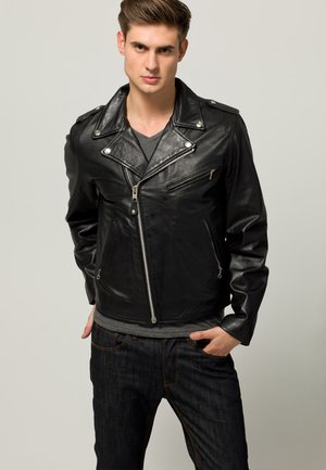 Black leather biker jacket with a diagonal zipper, epaulets, and zippered pockets. Worn over a gray t-shirt and displayed with dark jeans.