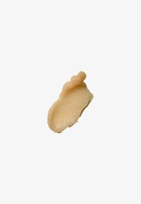 Baume cosmétique de couleur pêche avec une texture lisse, une forme légèrement courbée et un petit rebord surélevé.