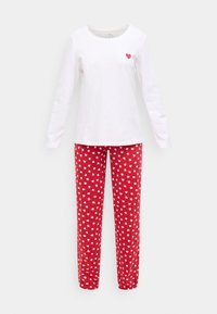 Λευκό μακρυμάνικο μπλουζάκι με μία μικρή κόκκινη καρδιά στο στήθος σε συνδυασμό με κόκκινο παντελόνι πιτζάμας καλυμμένο με λευκά σχέδια καρδιάς. Υλικό από βαμβάκι.
