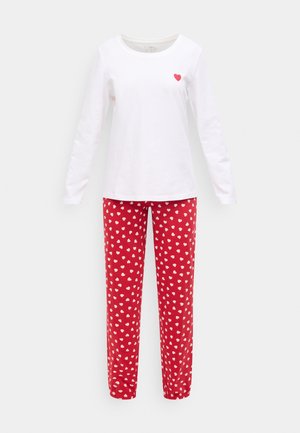 Baltas garām piedurknēm tops ar mazu sarkanu sirdi uz krūtīm, kopā ar sarkaniem pidžamas biksēm, kas klātas ar baltiem sirds rakstiem. Kokvilnas materiāls.