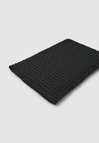 Plaid in maglia nera con texture a coste, forma rettangolare e dettagli di cucitura visibili, che conferisce un aspetto accogliente e caldo.