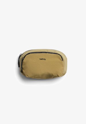 Petit étui en tissu beige avec deux compartiments à fermeture éclair noire, marqué "bellroy" à l'avant, conçu pour transporter de petits objets personnels.
